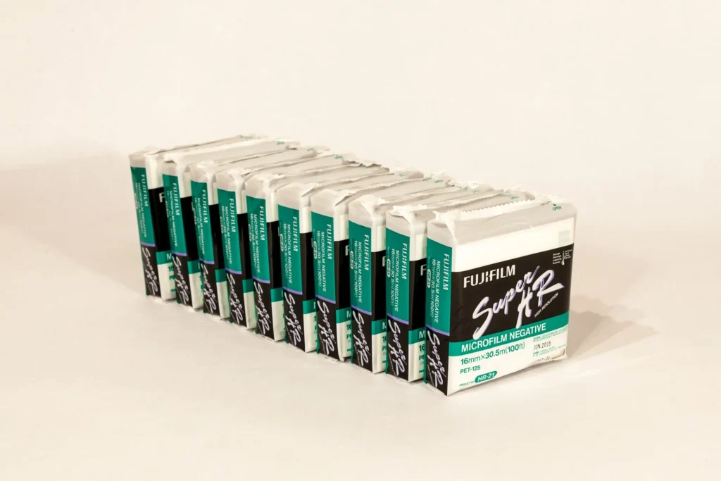 A photograph of multiple boxes of 16mm fujifilm microfilm