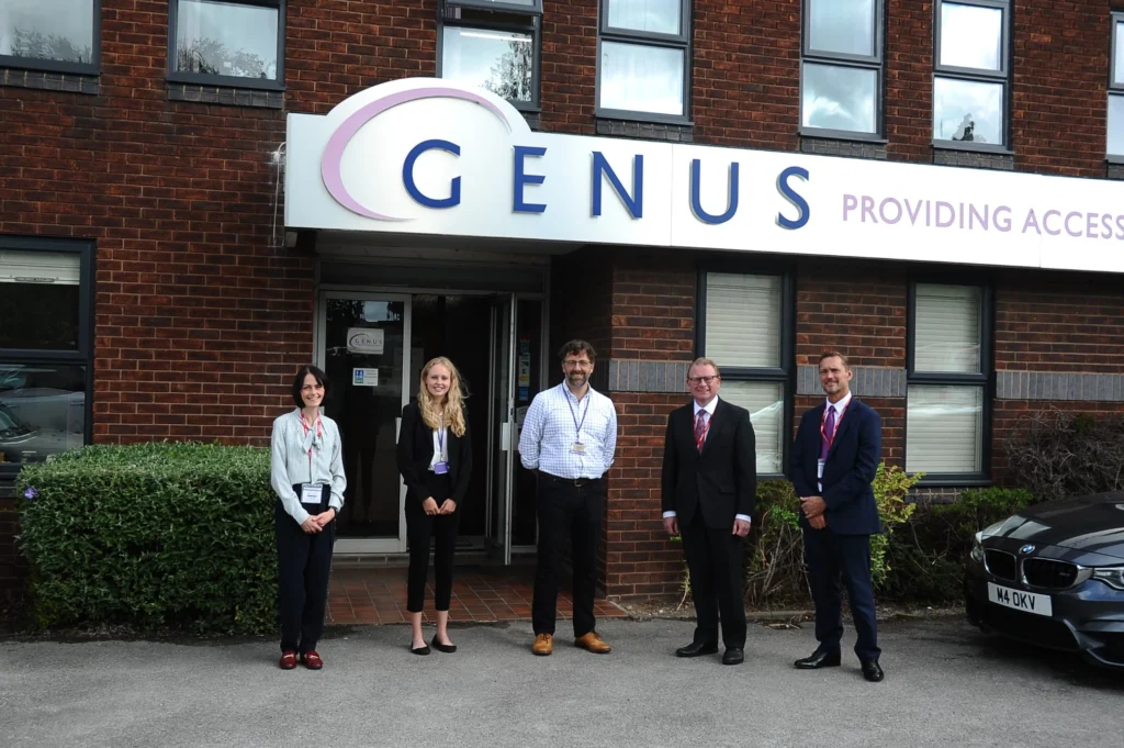 A photograph of Genus staff outside the building, accompanied by Nuneaton MP
