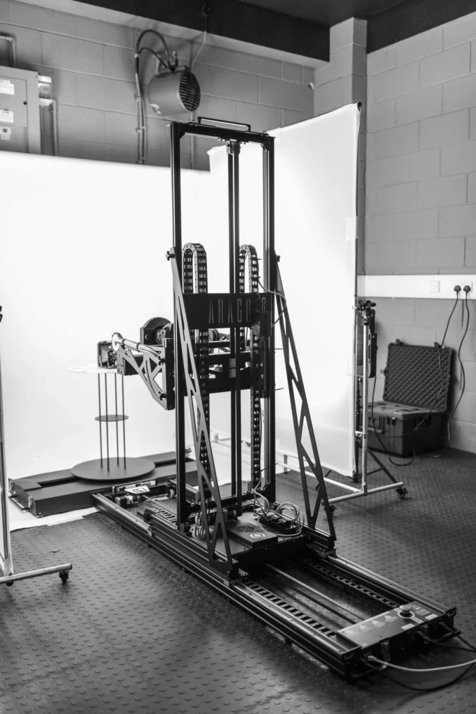 A black and white photograph of a 3D photogrammetry rig complete with backdrop and lights
