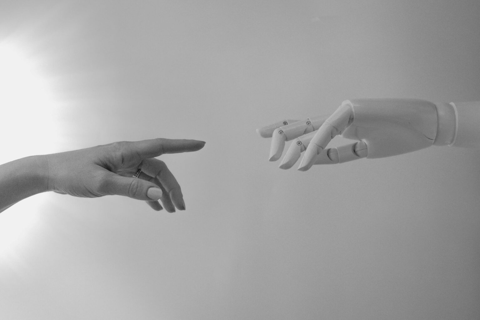 A human hand and a robotic hand recreating Michaelangelo's 'creation of adam' finger touch.